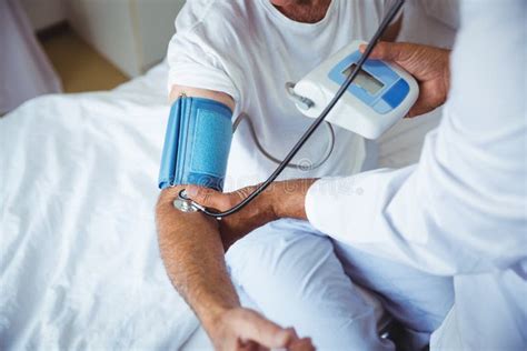 Nurse Measuring The Blood Pressure Of A Senior Man Stock Image Image
