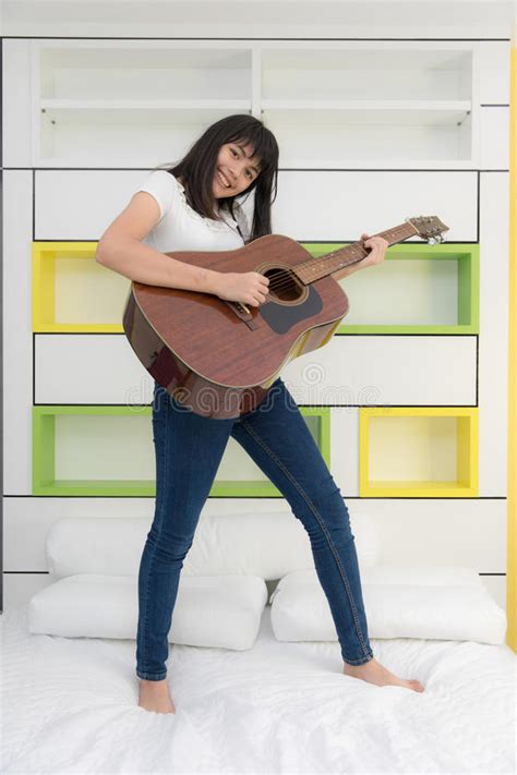 asian girl playing guitar in bedroom stock image image of musician people 94486395