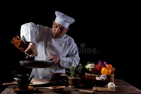 Male Chef In White Uniform And Hat Pouring Olive Oil Onto Cooking Pan