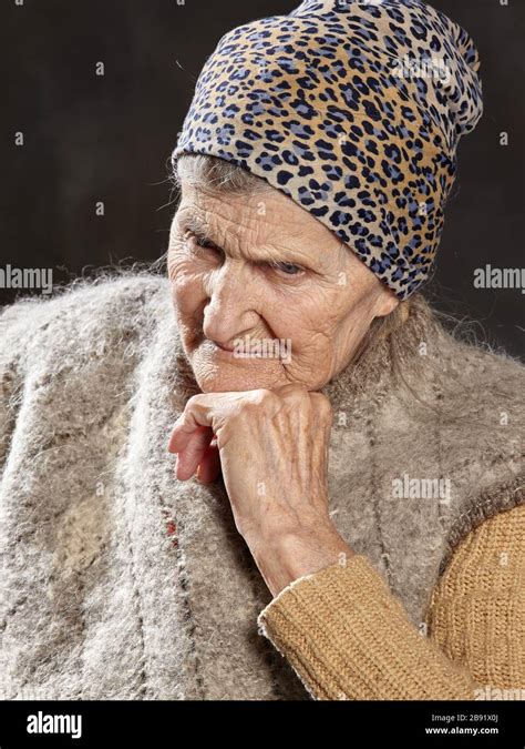 Close Up Portrait Of Old Woman With Brooding Look On Dark Background