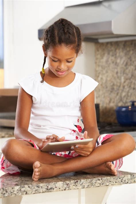 Girl Sitting On Kitchen Counter With Digital Tablet Stock Photo Image