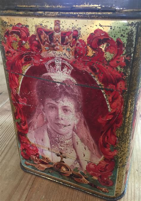 An Old Tin Box With A Painting Of A Woman Wearing A Tiara On It