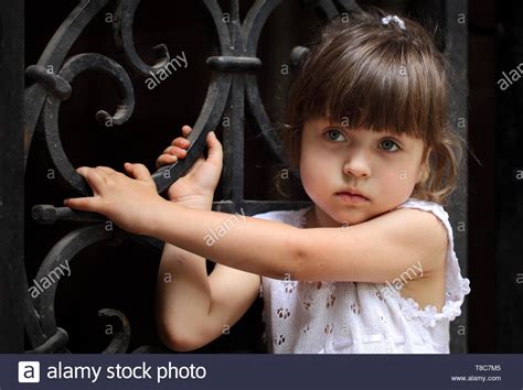 Little Girl Stands In Front Of The Door Stock Photo Alamy