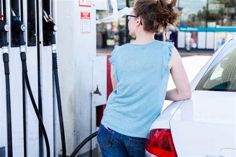 Image Of Young Woman Filling Up Her Car With Petrol At The Servo