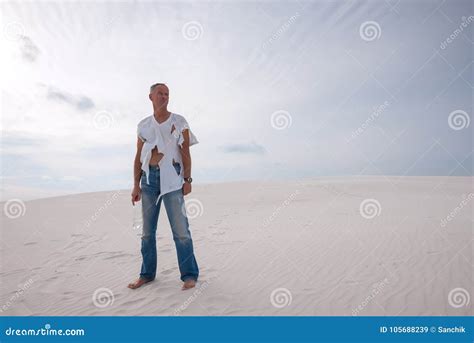 Exhausted Man Lost In The Desert Is Standing On A Sand Dune Stock