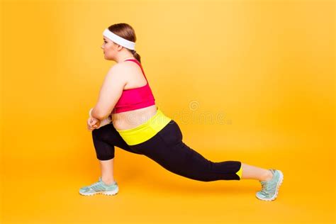 Side View Image Of Concentrated Flexible Plump Woman Clothed In Stock