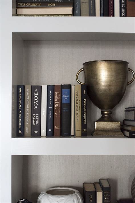Some Books And A Gold Trophy On Top Of A Book Shelf In A Room With