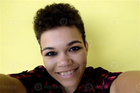 Beautiful And Happy African American Woman With Short Hair On A Yellow