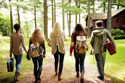 Group Of Teen Friends 16 17 Walking To Cabin By Lake