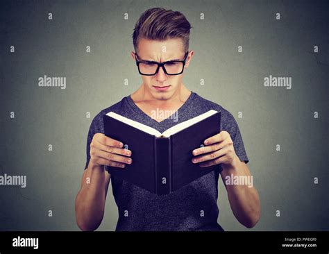 Young Man In Glasses Looking Confused While Trying To Read Smart Book