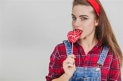 Pretty Pinup Girl Standing Licking Red Heartshape Lollypop Pleased Face