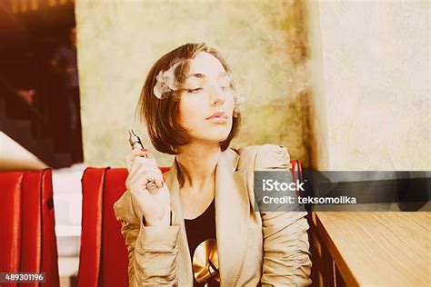 여자아이 좌석의 및 Smokes 전자 시가렛형 전자담배에 대한 스톡 사진 및 기타 이미지 전자담배 패션모델 2015년 Istock