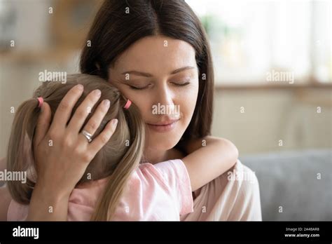 Happy Serene Mother Hugging Little Daughter With Love Close Up Stock