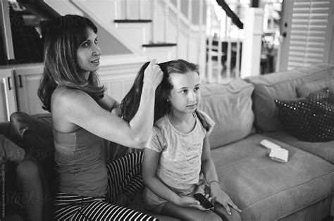 Mother Doing Daughter S Hair While Brother And Sister Are Watching Television By Stocksy
