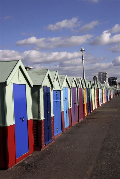 A Row Of Colorful Beach Huts Sitting Next To Each Other