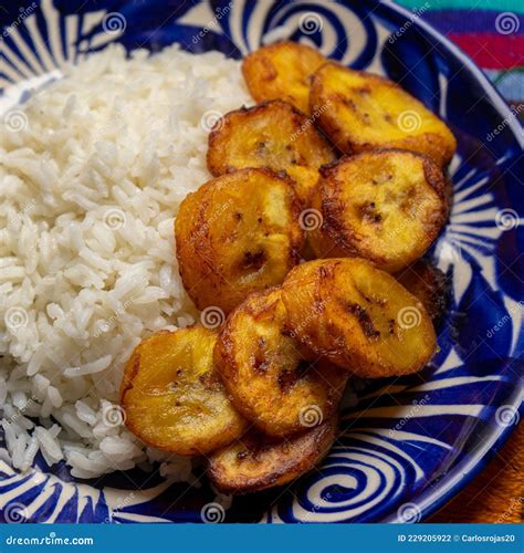Rice And Fried Banana Also Called Cuban Style On Rustic Background