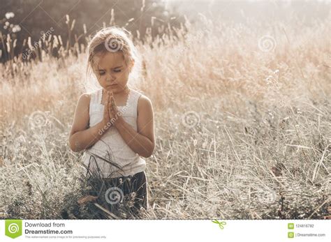 Little Girl Closed Her Eyes Praying At Sunset Hands