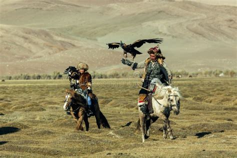 Berkutchi Kazakh Eagle Hunter While Hunting To The Hare With A Golden