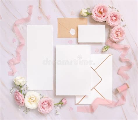 Cards And Envelope Between Pink Roses And Pink Silk Ribbons On Marble