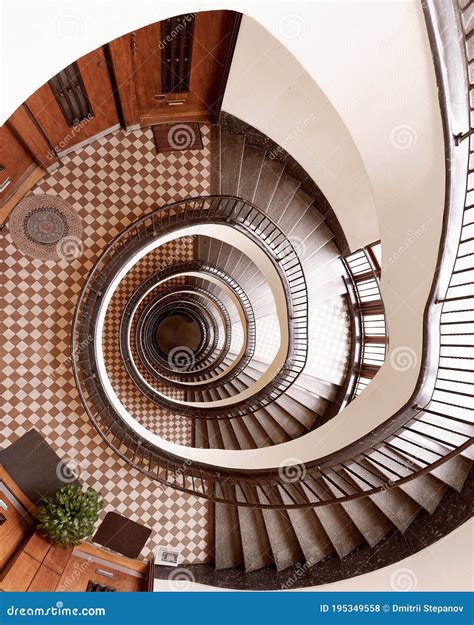 Brown Round Spiral Staircase With White Walls Black Railings With
