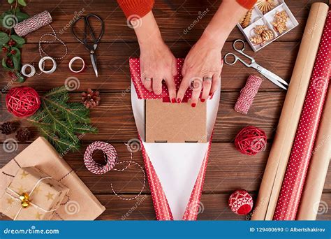 Woman S Hands Wrapping Christmas T On Dark Wooden Background Stock
