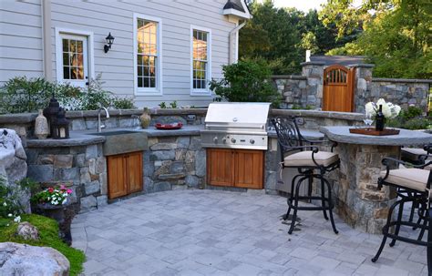 This outdoor kitchen is made of stones set on a deck. Outdoor Kitchen Design Essentials