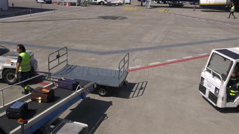 Airport Staff Putting Baggage On The Conveyor Belt Of Airplane Luggage
