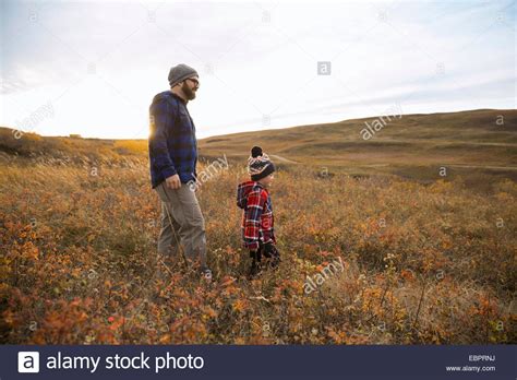 Father And Son Walking In Rural Field Stock Photo Alamy