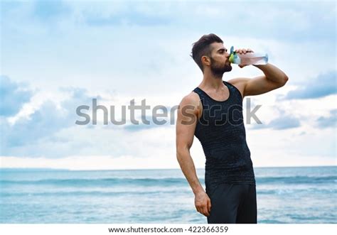 Foto Stock 422366359 A Tema Man Drinking Water After Running Workout