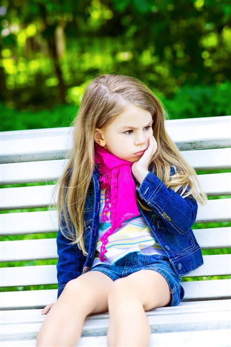 Smutny Blond Małej Dziewczynki Obsiadanie Na ławce W Parku Zdjęcie