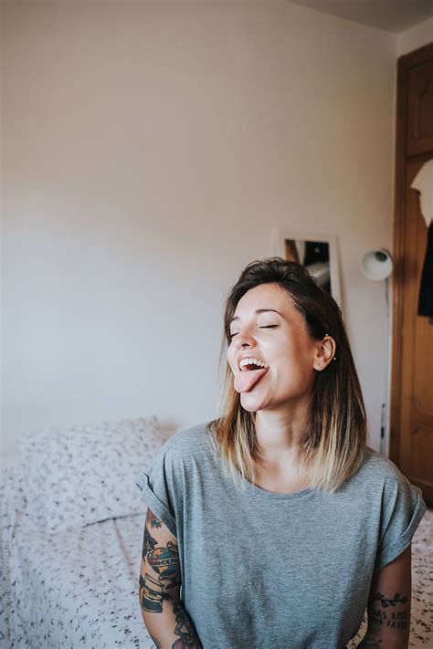 Portrait Of Woman Sitting On The Bed Sticking Out Her Tongue By