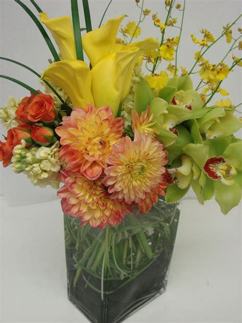 This Is An Arrangement Featuring Yellow Calla Lilies Orange Dahlias And Green Cymbidium Orchids