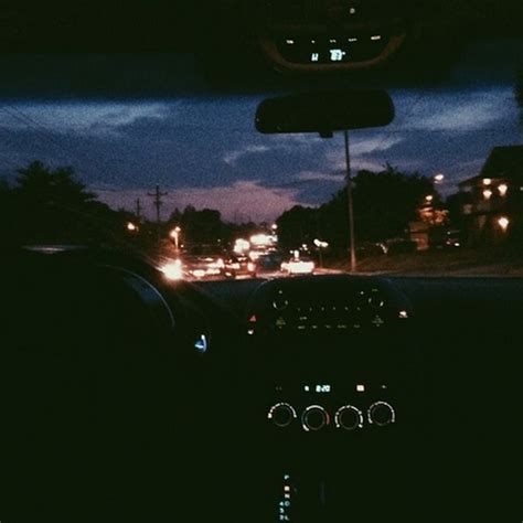 The Dashboard Of A Car At Night With Lights On And Dark Clouds In The