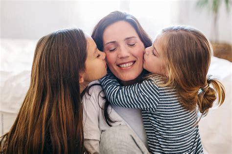 Portrait Of Daughters Kissing Her Mom At Home By Stocksy Contributor