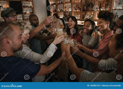 Friends In A Bar Cheering With Drinks In The Evening Stock Image