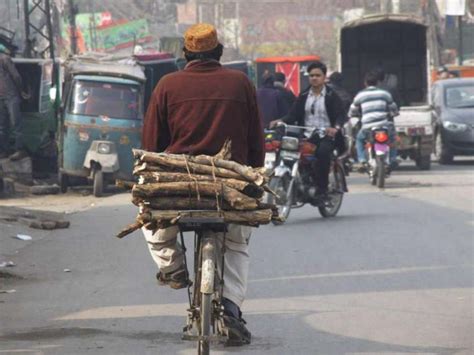 لاہور ایک سائیکل سوار گیس کی لوڈ شیڈنگ کے باعث گھر کا چولہا جلانے کے لیے لکڑیاں لیجا رہا ہے۔