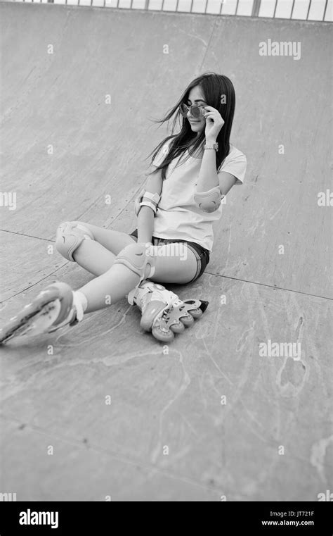 Portrait Of A Beautiful Girl Sitting On The Outdoor Rollerblading Rink