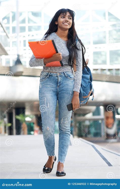 Full Body Indian Female College Student Walking In City With Books And