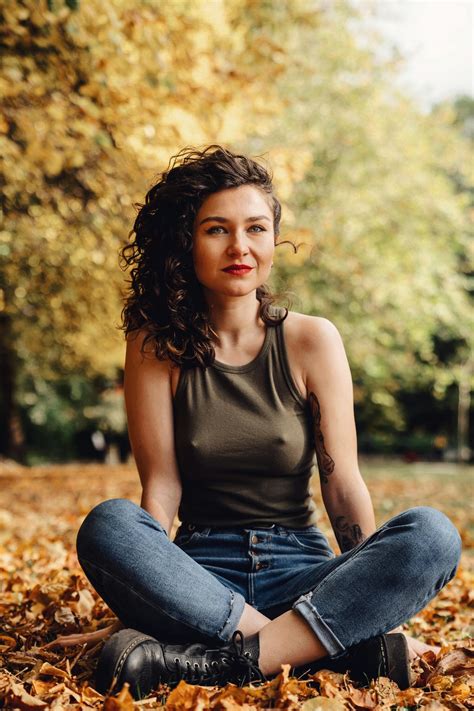 Woman In Black Tank Top And Blue Denim Jeans Sitting On Ground · Free