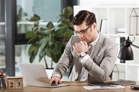 Handsome Focused Businessman Working With Laptop At Office Stock