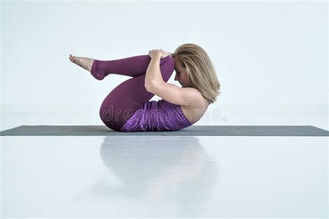 Woman Practicing Yoga Doing Knees To Chest Exercise Apanasana Pose