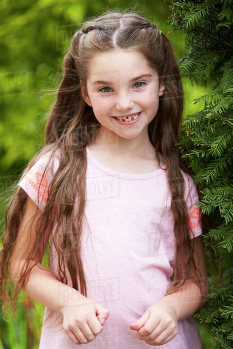 Portrait Of Smiling Young Girl Standing Outdoors In Garden Stock