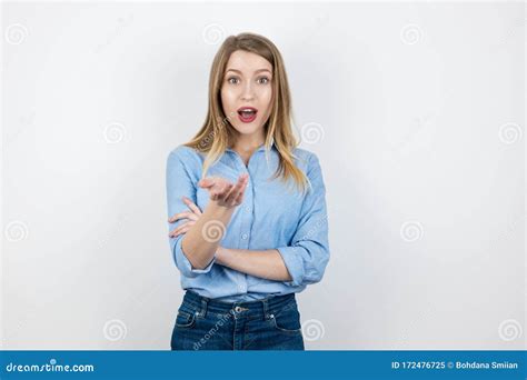 Young Blond Surprised Woman Looks Curious Pointing With Her Hand