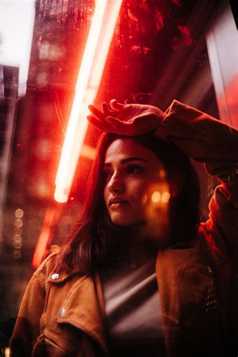 A Woman Standing In The Middle Of A City At Night With Lights On Her Head