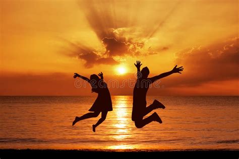 Young Couple In A Jump On The Sea Beach At Sunset Stock Image Image
