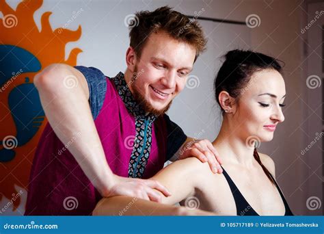 Young Male Massage Therapist Doing Relaxing Massage For A Girl In Black