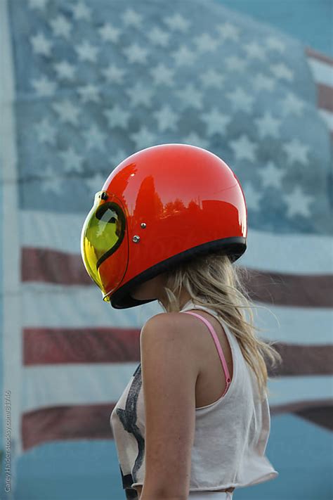 Americana Youthful Woman Wearing A Motorcycle Helmet Infront Of An