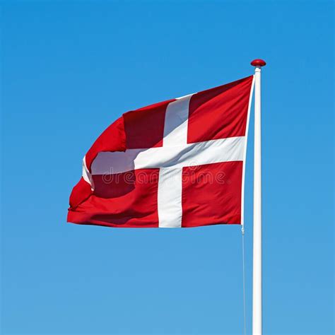 The Danish Flag The Danish Flag Blowing Against A Blue Background