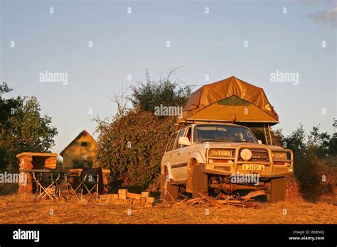 Toyota Land Cruiser 4x4 With Tent Loaded Onto Its Roof At A Campsite In