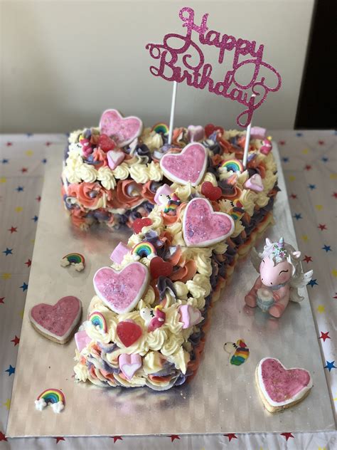 A Birthday Cake That Is Shaped Like The Number One With Hearts And